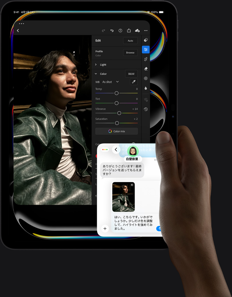 縦向きにしたスペースブラックのiPad Proの前面の外観。右手でデバイスを持っている。ディスプレイに写真編集アプリが表示されており、皮のジャケットを着た人物の写真と、編集ツール、スライダが表示されている。ユーザーがその写真について他の人と意見を交換しているiMessageの会話も表示されている