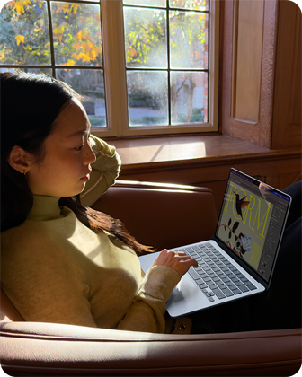 Cilvēks, kas sēž krēslā un strādā ar savu MacBook Air