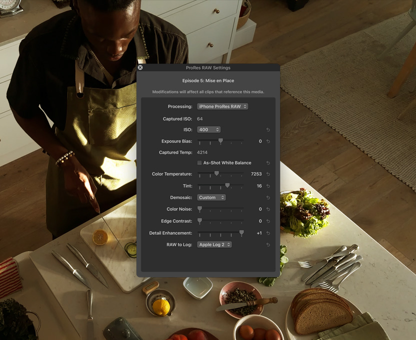 Écran d’un iPhone 17 Pro affichant des workflows professionnels pour la réalisation d’une vidéo, un homme se tient debout dans une cuisine et découpe des légumes sur un plan de travail.